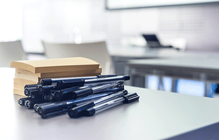 Pens and Post-it notes arranged on the left side of the table.
